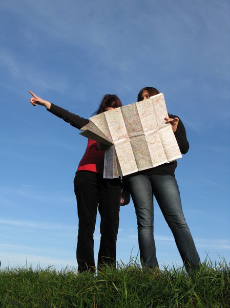 2 women reading a map and pointing in the direction to head.