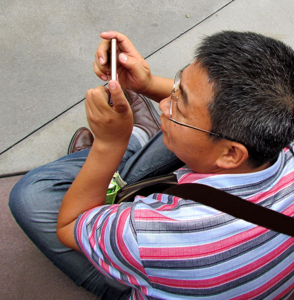 Man using mobile phone while sitting on the floor.